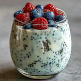 Vanilla bean yogurt chia pudding, light and airy, served in a glass with a drizzle of honey and sliced banana on top.  