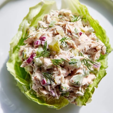A close-up of Dill Pickle Chicken Salad Lettuce Cups, with creamy dressing, red onion, and fresh dill visible in the tender butter lettuce.  