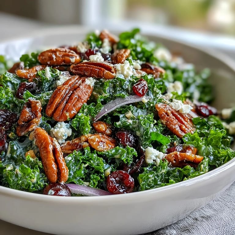 Comforting Warm Kale Salad with Maple Mustard Dressing tossed with crunchy nuts and cranberries, served on a wooden board.